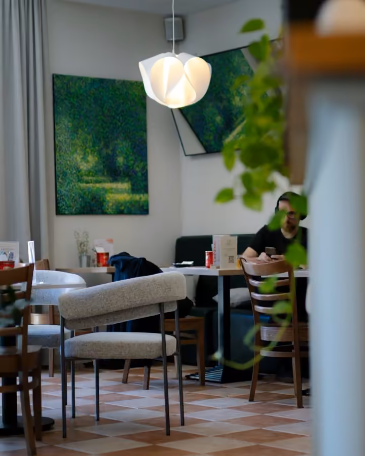 Sala De Novo: stoliki, lampa i zieleń za oknem